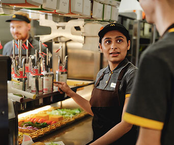 Młoda pracowniczka McDonald's w kuchni