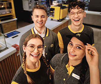 4 uśmiechniętych młodych pracowników McDonald's